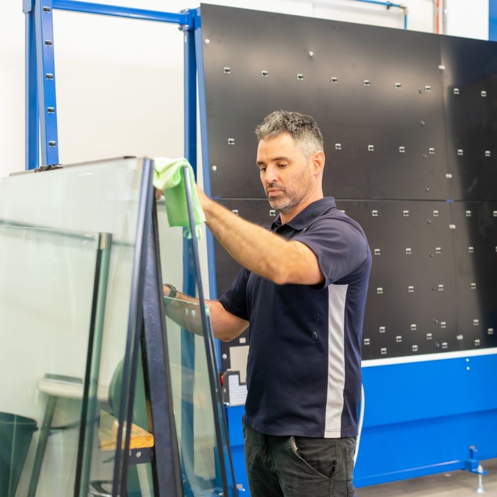 man cleaning glass before loading hydrophobic glass coating machine